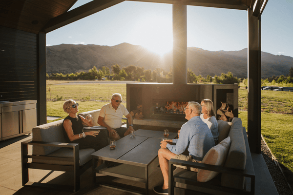 friends sitting around a Burton outdoor fireplace in the sun
