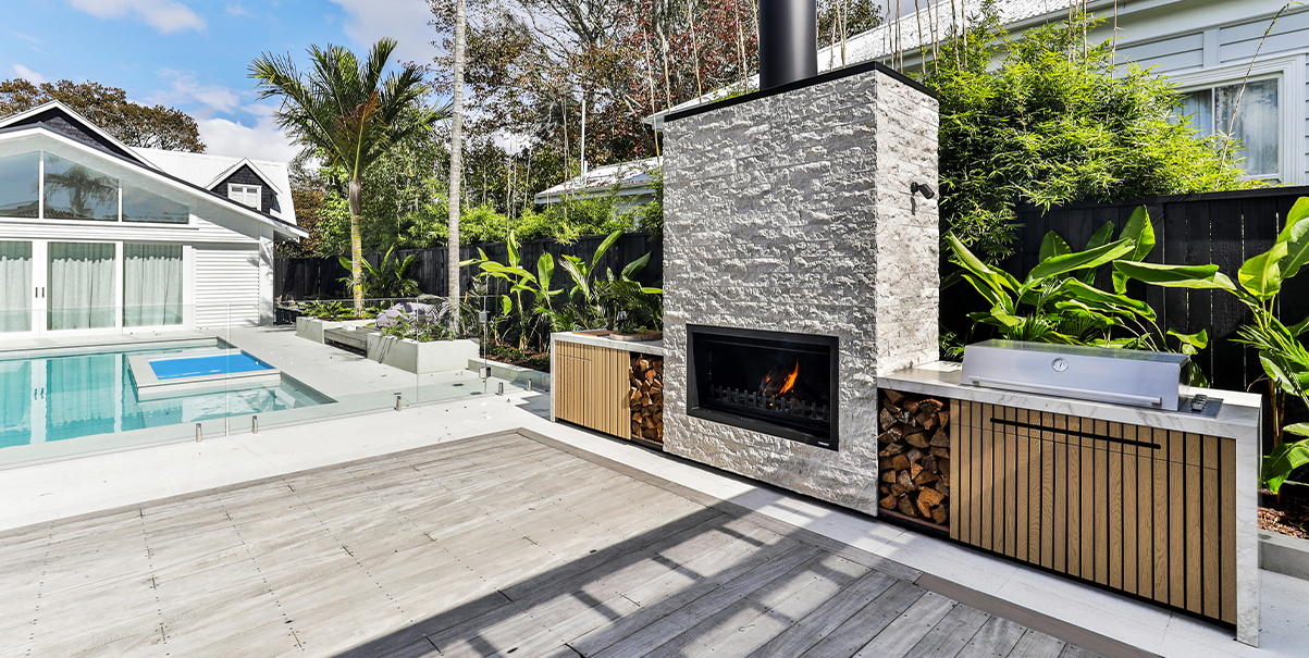 custom fireplace structure outdoor kitchen beside pool