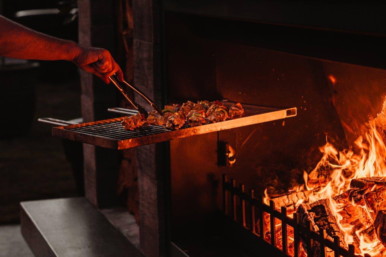 cooking on swinging cooking grill on outdoor fireplace